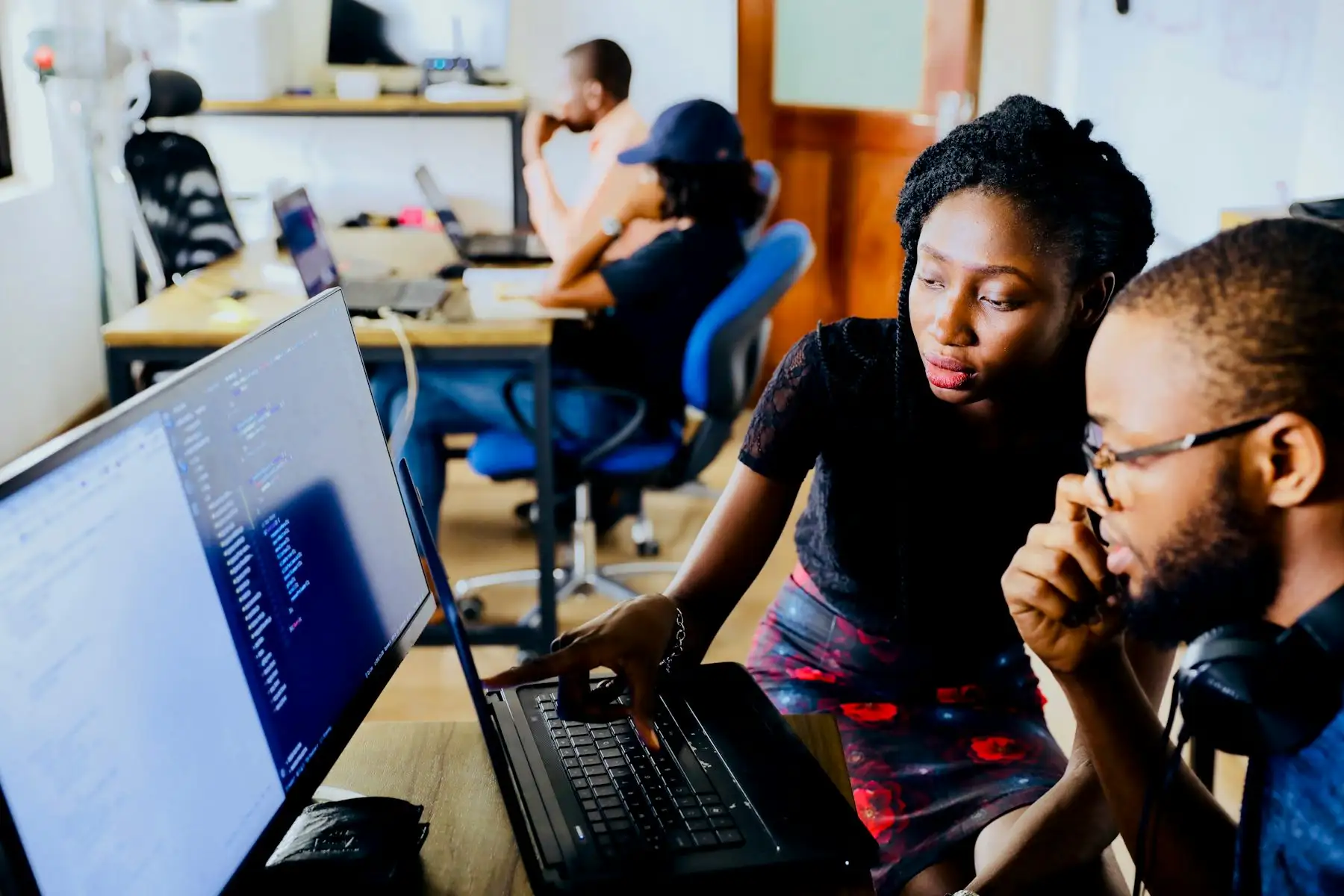 Two founders reviewing work together at a shared screen